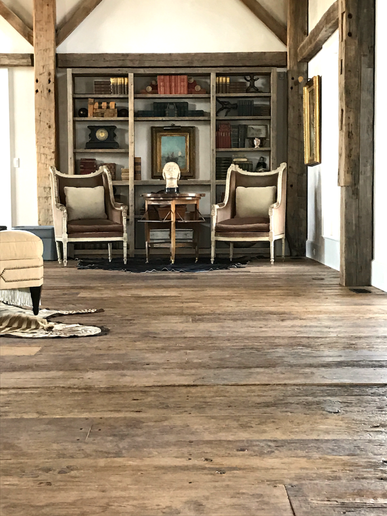 Living room featuring reclaimed threshing floor in a converted barn residence in Pemaquid, Maine